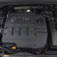 Silnik 2.0 TDI 190 KM. Widok na pokrywę silnika z logo VW i napisem TDI. W tle zbiornik płynu chłodniczego.