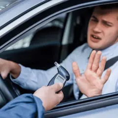 Mann im Auto wehrt sich gegen Alkoholtest. 1,1 Promille Strafe droht.