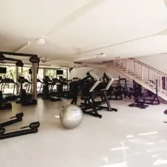 Jasna, nowoczesna siłownia z bieżniami, maszynami do ćwiczeń i piłką gimnastyczną. Idealne miejsce na treningi mcfit multisport.