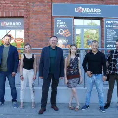 Lombard życie pod zastaw obsada: uśmiechnięci pracownicy lombardu pozują przed budynkiem.
