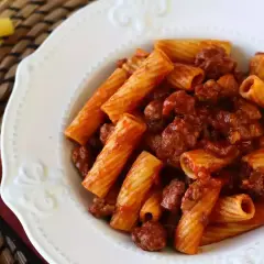 En tallrik med rigatoni pasta och en smakrik köttfärssås. Enkel och god salchicha pasta.