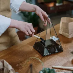 Manos creando un terrario con herramientas de jardinería, parte de manualidades con cosas de casa.
