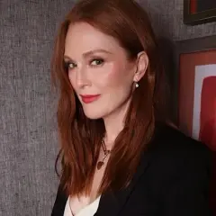 Eleganckie stylizacje do rudych włosów: Julianne Moore w czarnej marynarce i z subtelną biżuterią.