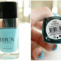 En flaska IDUN Minerals nagellack i färgen turkos. En hand med matchande turkos nagellack håller flaskans undersida.