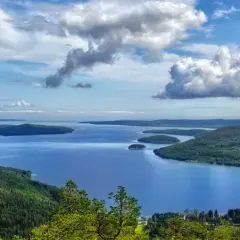 Vacker utsikt över en sjö med öar och skogsklädda berg. Perfekt för naturupplevelser nära Stockholm.