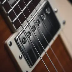 Zbliżenie na przetwornik i struny gitary elektrycznej, idealne do tworzenia eterycznego shoegaze.