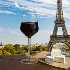 Ett glas rött vin och ost framför Eiffeltornet, som används för att visa upp Paris kultur och skönhet.