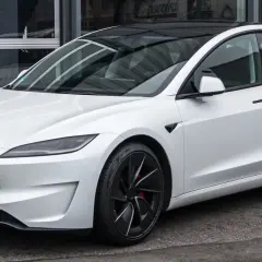 Tesla Model 3 blanco con techo negro. Su diseño aerodinámico sugiere una gran autonomía, optimizando la capacidad de la batería para viajes largos.