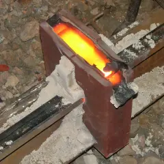 Żelazny szynoprzewód połączony metodą spawania termitowego. Roztopiony metal płynie w formie, tworząc mocne połączenie.