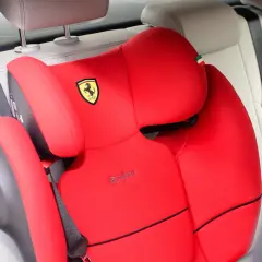 Czerwony fotelik samochodowy Cybex z logo Ferrari, gotowy do montażu. Instrukcja jak zamontować fotelik w samochodzie.