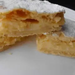 Kruche ciasto przełożone kremem, posypane cukrem pudrem. To smak dzieciństwa, czyli napoleonka przepis babci.
