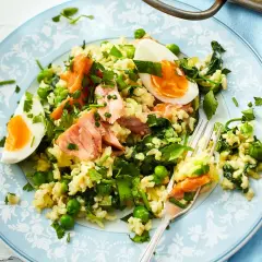 Reisgericht mit Lachs, Erbsen und Ei – ein Beispiel für gesund und lecker kochen. Frische Kräuter verfeinern die Mahlzeit.