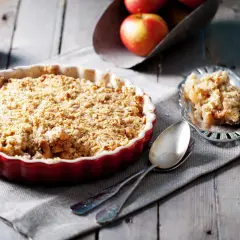 Un délicieux crumble pomme tout juste sorti du four, prêt à être dégusté. Des pommes fondantes sous une couche croustillante.