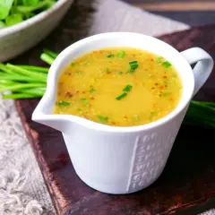 Ein cremiges Dressing für Feldsalat, verfeinert mit Senfkörnern und Schnittlauch, bereit zum Servieren.