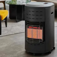 Chauffage gaz infrarouge, avec sa grille protectrice et ses éléments chauffants rougeoyants, diffuse une chaleur réconfortante dans un salon moderne.
