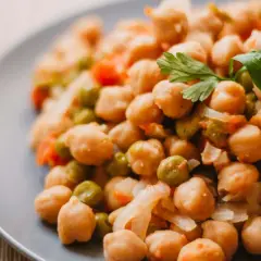 Plato de garbanzos guisados con guisantes y zanahoria, perfecto para una receta saludable.