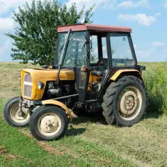 Żółty Ursus C-360 na łące. Zastanawiasz się, ile oleju do skrzyni C 360? Ten traktor czeka na pracę.