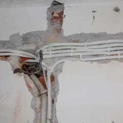 Nowe przewody elektryczne w ścianie, przygotowanie do wymiany instalacji elektrycznej.