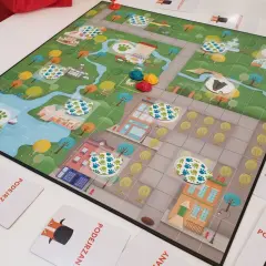 Kolorowa plansza do gry z motywem miasta i śladami łapek, idealna na gry planszowe dla 6 osób.