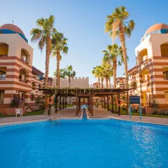 Basen i palmy przy hotelu w Port Ghalib. Architektura w stylu orientalnym z kopułami i łukami.