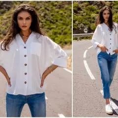 Kobieta w białej koszuli oversize i jeansach na drodze. Stylowe, luźne ubranie na co dzień.