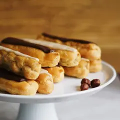 Una pila di éclair con glassa al cioccolato e vaniglia, pronti per essere gustati. La ricetta perfetta per un dolce momento.