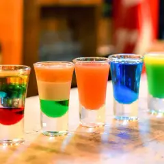 Kolorowe shoty alkoholowe, tęczowe i warstwowe, gotowe do degustacji.