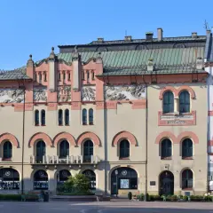 Elegancka fasada Teatru Starego w Krakowie z ozdobnymi detalami i łukowymi oknami.