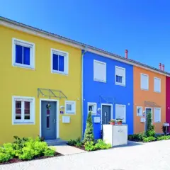 Reihenhäuser in leuchtenden Farben: Gelb, Blau, Orange, Pink. Tolle hausfassade farbe ideen für ein fröhliches Zuhause.
