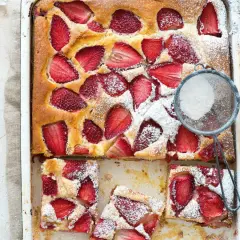 Le gâteau aux fraises de maman, doré et garni de fruits rouges, est saupoudré de sucre glace. Un délice !