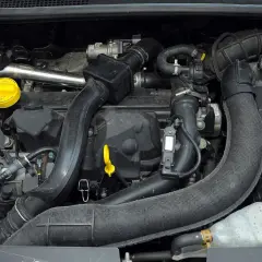 Silnik Renault Clio 3 z widocznymi przewodami, czujnikami i żółtym korkiem oleju.