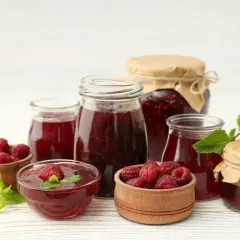 Słoiki z domowym dżemem malinowym i świeże maliny. Idealny sok z malin przepis na lato.