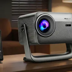 Nowoczesny projektor z Dolby Audio, idealny jako projektor do domu. Obok smartfon z aplikacją muzyczną.