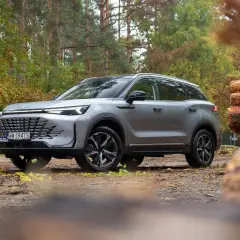 Srebrny SUV na leśnej drodze. Wiele osób szuka baic 7 opinii przed zakupem.