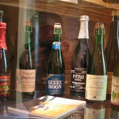 Rząd butelek piwa Lambic, w tym Oude Geuze Boon i Faro Lindemans.