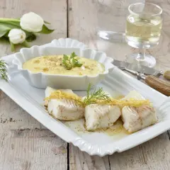Elegancki halibut przepis: delikatne kawałki ryby z cytrynową skórką i koperkiem, podane z kremowym sosem. Idealne danie.
