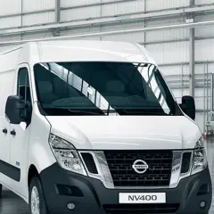 Biały van Nissan NV400 stoi w przestronnym magazynie.