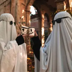 Dwa duchy w okularach przeciwsłonecznych wznoszą kubki z dyniami. Prosty strój, jak zrobić strój Hefajstosa, ale na Halloween!