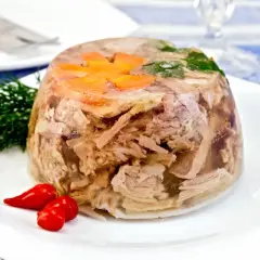 Pyszna galareta wieprzowa z marchewką i koperkiem, podana z papryczkami chili. Czas jej tężeje to kwestia cierpliwości.