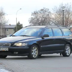 Ciemny czarny kombi Volvo V70 zaparkowany na zewnątrz.