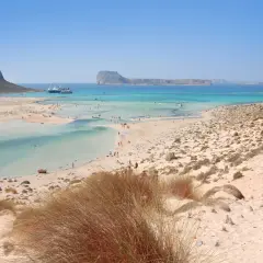 Piękne plaże na Krecie, Chania. Turkusowa woda, piaszczyste wybrzeże i góry w tle.