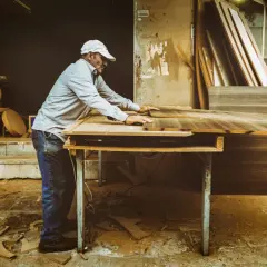 Artisan ajustant des planches de bois. Si votre cuisine est mal posée, quel recours ?