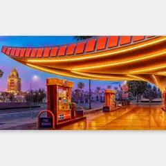 Alex Israel's vibrant painting captures a retro 76 gas station at dusk, with a grand building and palm trees in the background.
