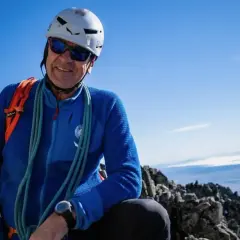 Uśmiechnięty wspinacz w kasku i okularach przeciwsłonecznych na szczycie, z liną przewieszoną przez ramię. To jego **Gerlach bez przewodnika**!