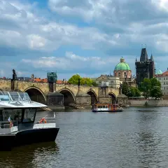 Rejs po Wełtawie czy warto? Widok na Most Karola z łodzią turystyczną.