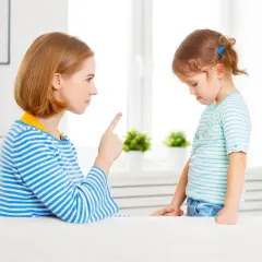 Matka karci dziecko, wskazując palcem.