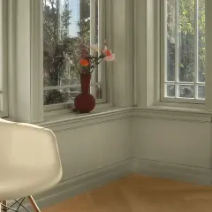En ljus hall med en vit stol och en vas med blommor på fönsterbrädan. Väggarna är målade i en lugn grön nyans.