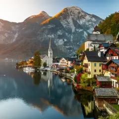 Hallstatt, Austria, un pueblo alpino con casas coloridas y una iglesia, reflejado en un lago sereno. Un ejemplo de los países más bonitos de Europa.