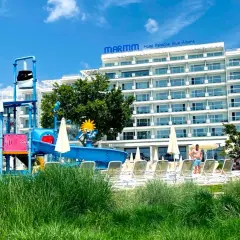 Hotel Paradise Blue Albena z placem zabaw wodnym i leżakami na tle błękitnego nieba.