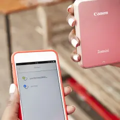 Jak połączyć drukarkę Canon z telefonem? Na ekranie telefonu widać listę drukarek, w tym Canon Mini Printer.